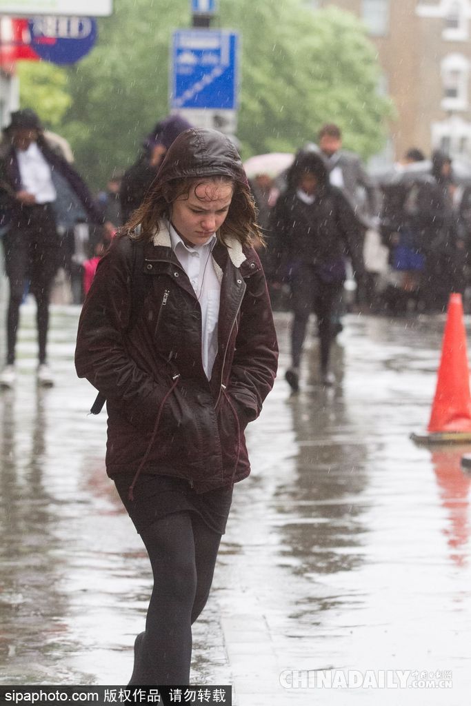 英國倫敦雨天狂風(fēng)大作 民眾出行雨傘被吹翻