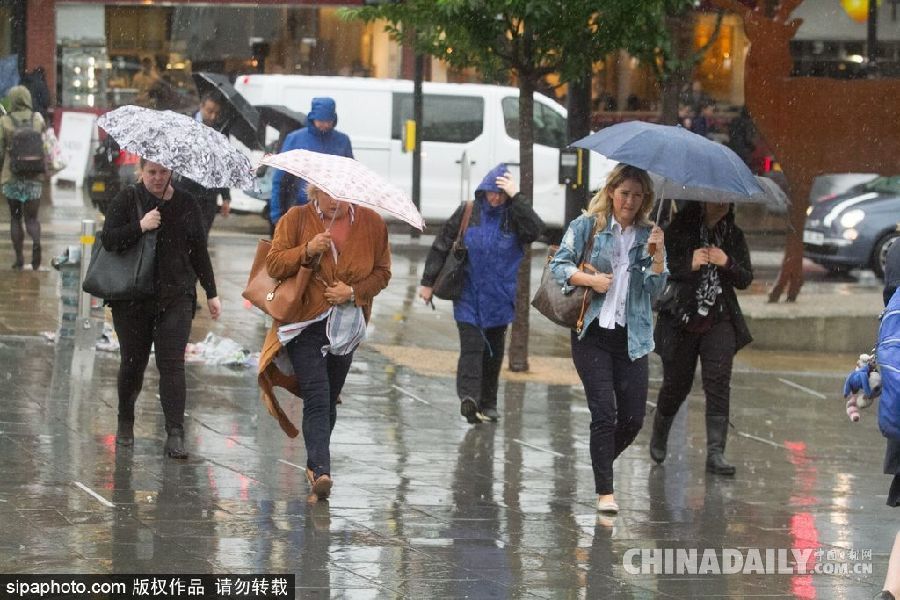 英國倫敦雨天狂風(fēng)大作 民眾出行雨傘被吹翻