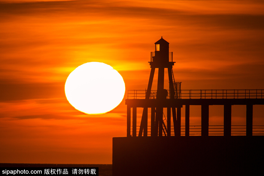 英國惠特比碼頭日出風光 燈塔影影綽綽景色美