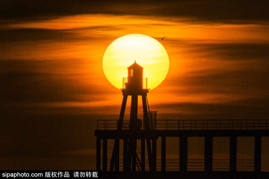 英國(guó)惠特比碼頭日出風(fēng)光 燈塔影影綽綽景色美